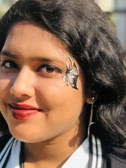 The finished look of a silver and black butterfly, with the client smiling. It's a joy to see people happy with my art.