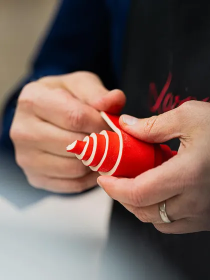 Chef Bachour demonstrates how to create a vibrant, multi-colored spiral decoration, a signature technique that adds a modern artistic touch.