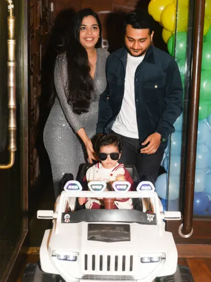 The grand entrance! The birthday boy arrives in style in his toy jeep, guided by his proud parents.