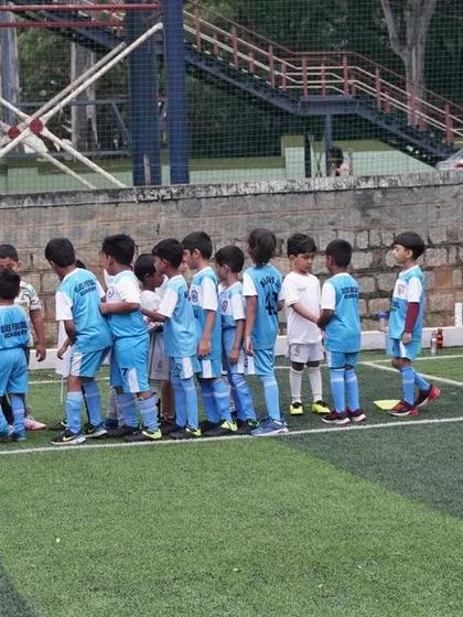 Our U5 team huddles with their coaches before a practice match against Real Madrid Football Academy.
