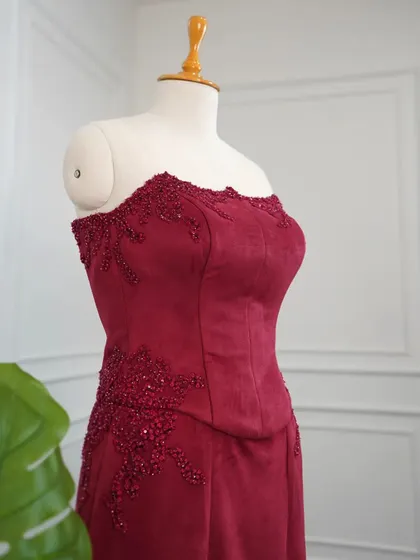 The rich scarlet hue of this suede bodycon dress is designed to make a statement. The handcrafted corset bodice provides structure and elegance.