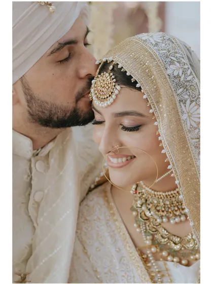The gentle press of a kiss on the forehead is a universe of love. This tender moment from a Nikaah ceremony, captured in our signature clean and elegant style, speaks volumes about the couple's deep affection and bond.