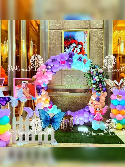 A circular balloon arch decorated with butterflies and fairies creates a beautiful and unique photo booth for guests.