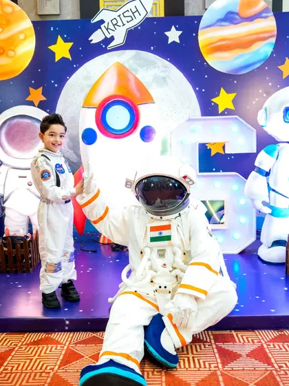 A magical moment as the birthday boy, dressed in a matching costume, poses with our astronaut mascot at his space-themed party.