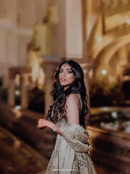 A beautiful portrait of the bride looking over her shoulder, with the softly lit palace corridors in the background.