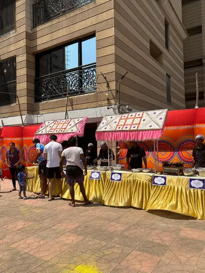 A full view of my food stall setup for a large society Holi party. The colorful backdrop and festive canopies create the perfect atmosphere for a day of fun and food.