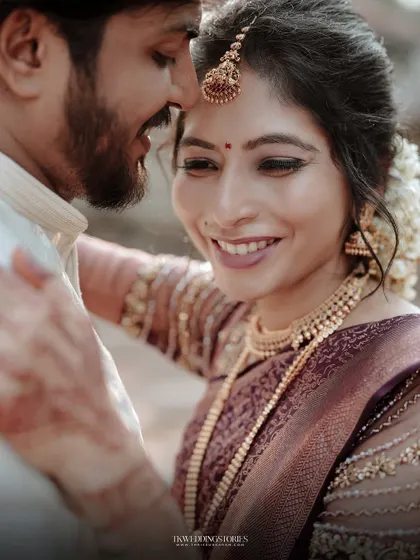 A candid and happy moment between a newly married South Indian couple, capturing their genuine smiles and affection.