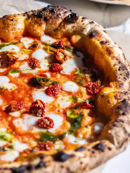 A close-up of my Sundried Tomato & Basil Pizza. The sweetness of the tomatoes and the fresh, herbaceous notes of the basil pesto create a vibrant and flavorful combination that feels like sunshine on a plate.