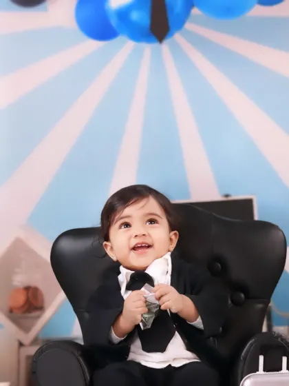 A happy boss baby in a tiny suit looks up with a bright smile, ready to close his next big deal.