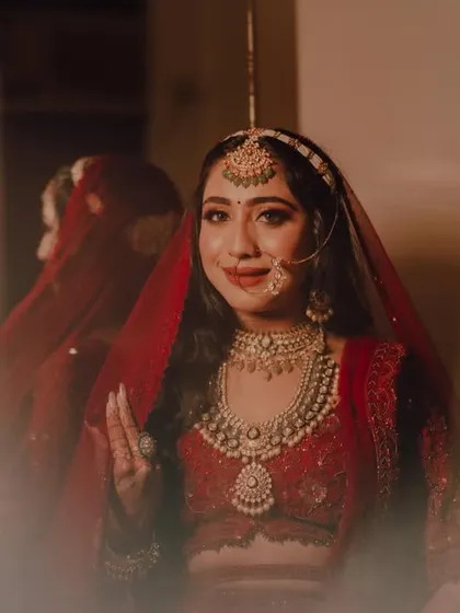 A beautiful bridal portrait taken through a reflection. The bride, Divya, looks elegant and serene as she gets ready for her big day.