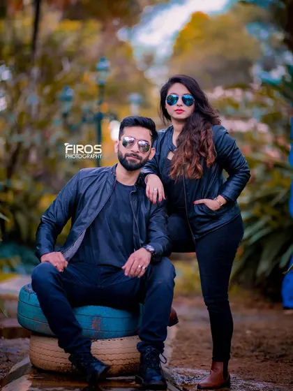 The classic "biker chic" look. Dressed in matching black leather jackets and sunglasses, this couple exudes confidence and style in this cool, edgy portrait.