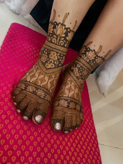 A beautiful floral foot mehendi. The design features bands of lotus flowers and other traditional patterns, creating a rich and intricate look.