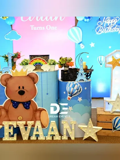A closer look at the details for Evaan's party, including the crowned teddy bear, hot air balloon props, and a large light-up number '1'.