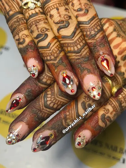 This is where art meets tradition. I designed this custom bridal set with ruby-red and silver gems to perfectly complement the beautiful, deep tones of the mehendi. It's all about creating a look that feels both royal and personal for your special day.