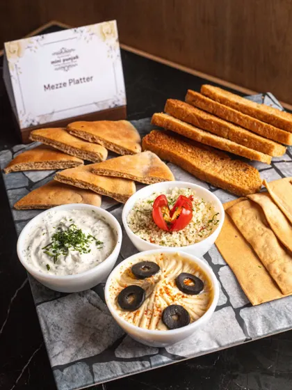 A closer look at our beautifully arranged Mezze Platter. The combination of creamy dips and different types of bread offers a delightful taste of Middle-Eastern hospitality.