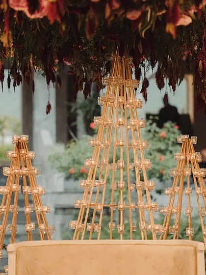 A close-up of the candle-lit pyramids that formed the backdrop for a traditional Bunt ceremony. These custom structures, combined with deep red floral arrangements, created a warm, glowing ambiance.