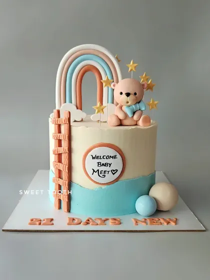 Welcoming baby Meet on his 21st day in this world. This blueberry cake features a sweet teddy bear, a boho rainbow, and a ladder to the stars.