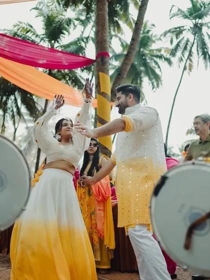 The couple makes a grand entrance to their Haldi ceremony, dancing to the energetic beats of the dhol. I orchestrate every moment to be full of life and celebration.
