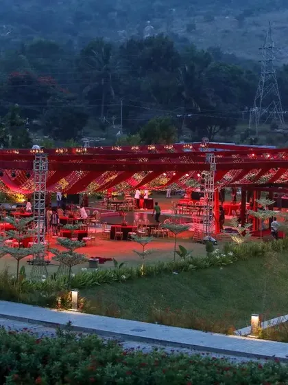 A wide view of a reception designed to impress. The entire venue, set against the mountains, was transformed with dramatic red lighting and a signature windmill feature, creating a truly magical destination wedding experience.