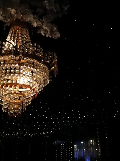 A stunning crystal chandelier hangs against a backdrop of a thousand tiny fairy lights, creating a "starry night" ceiling. This is how we use lighting to build a truly magical and dramatic atmosphere.