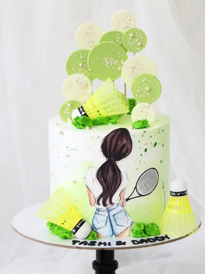 A creative cake designed for a badminton champion. This piece features a hand-painted player, edible shuttlecocks, and a vibrant green splatter effect, capturing the energy of the sport.