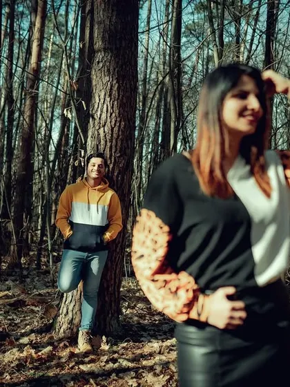 A creative portrait of a couple in a German forest. The composition plays with depth, creating a sense of discovery and intimacy within the natural landscape.