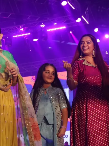 A candid moment with Jaya Kishori and a young fan on stage, highlighting the inclusive and family-friendly atmosphere I help create.