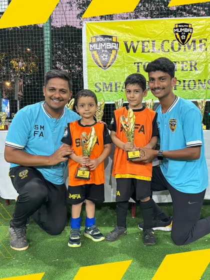 Two more little champions with their coaches. The smiles on their faces show the joy and pride they feel.
