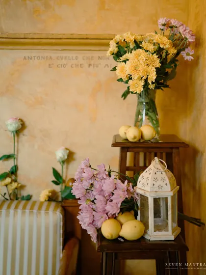 The quiet details of a haldi ceremony in Italy. I used simple, rustic elements like fresh lemons, yellow chrysanthemums, and a white lantern to style this corner, bringing a touch of Indian sunshine to the shores of Isola del Garda.
