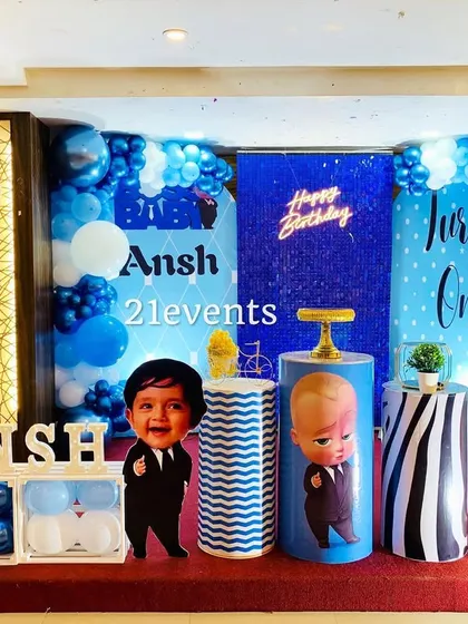 A classic Boss Baby theme in shades of blue, white, and black. The setup includes a sequin backdrop, character cutouts, and a light-up number '1'.