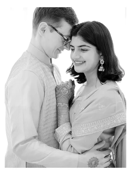 A tender black and white portrait of a multicultural couple, capturing their gentle connection and happiness in a high-key, minimalist style.