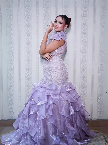 A side view of the lilac gown, showcasing the beautiful ruffled train.