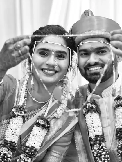 A timeless black and white photo of the couple holding their Mundavalya, a signature element of a Maharashtrian wedding.