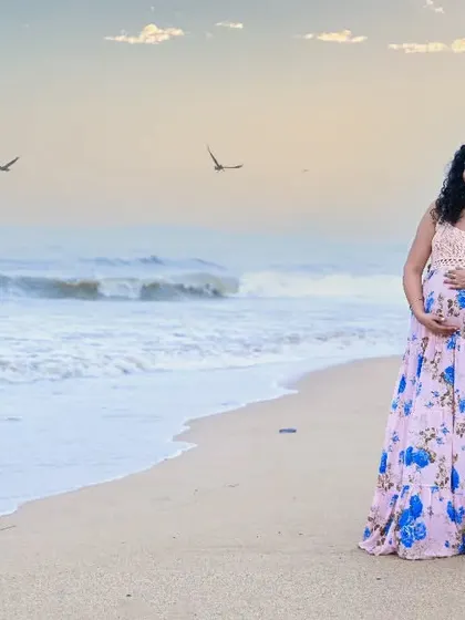 A stunning wide shot of an expecting couple on the beach. The vastness of the sea and sky provides a dramatic backdrop for this beautiful moment of anticipation.