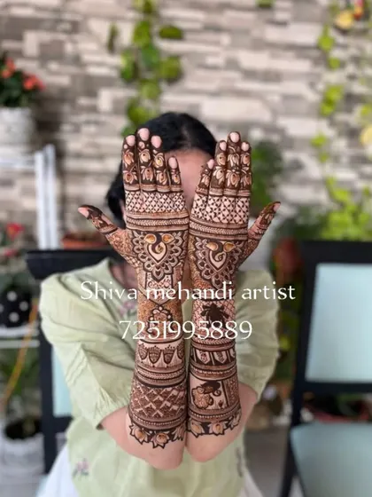 A classic and elegant full-sleeve bridal mehendi. This design focuses on traditional Indian motifs, with majestic peacocks on the palms and a royal elephant figure on the forearm, all tied together with intricate patterns.