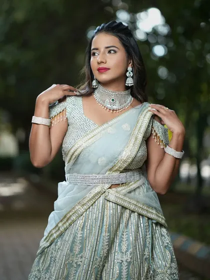 The off-shoulder blouse with beaded tassels adds a trendy touch to this elegant grey lehenga.