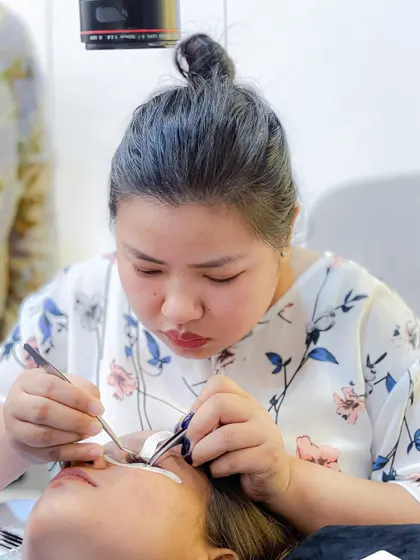 A student practices the precise art of applying individual lash extensions, a core skill taught in our comprehensive certification course.