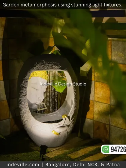 A beautiful Buddha water fountain, spotlit in a quiet corner of the garden. The gentle sound and sight of water, combined with soft light, create a deeply tranquil experience.