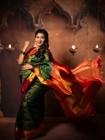 A joyful solo portrait of the mother-to-be. The flowing saree and her radiant smile capture the excitement and beauty of her pregnancy, set against a warm, traditional studio backdrop.