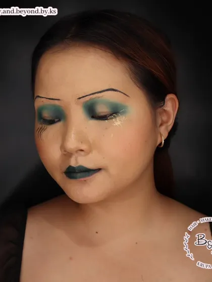 A view with the eyes closed shows the blended, dark green eyeshadow that creates the moody 1920s feel. The look is completed with a deep green cupid's bow lip, another signature element of the time.