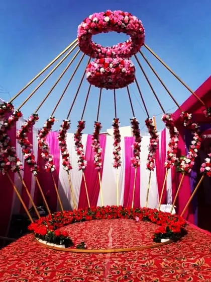 A unique floral mandap prop. The design creates a beautiful, semi-enclosed space for the ceremony, with flowers appearing to radiate from the center.