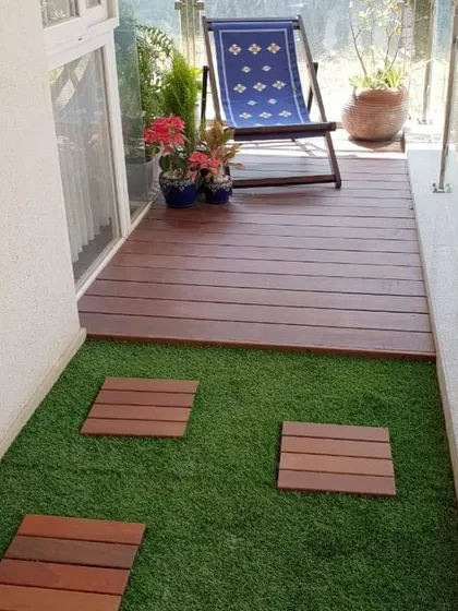 We created a split-level effect on this small balcony by installing a raised WPC deck for seating and an artificial grass area with stepping stones. This design adds depth and functionality to the space.