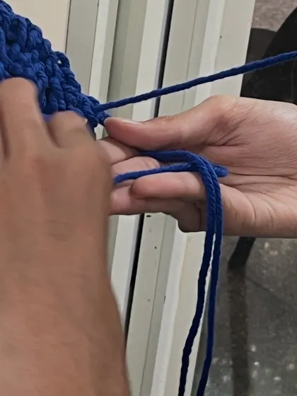 A close-up of hands tying a macrame knot. This craft is entirely about the sense of touch and the methodical process of creating something beautiful with your hands.