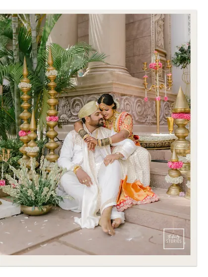 An intimate portrait of the couple seated on the steps of their venue. The groom's embrace and the bride's contented expression speak volumes about their bond.