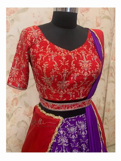A closer look at the detailed embroidery on the red blouse for the half saree.