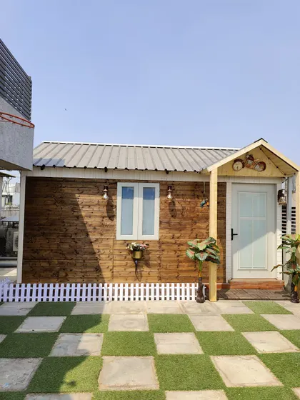 We offer a variety of styles to match your vision. This charming prefabricated cottage brings a rustic, cozy feel to a city rooftop, creating a perfect personal getaway with its wood-paneled exterior and welcoming entrance.