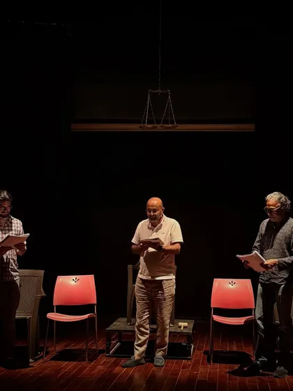 Actors reading their scripts during a rehearsal for "Inherit the Wind." The rehearsed reading format puts a strong emphasis on vocal performance and the power of the text.