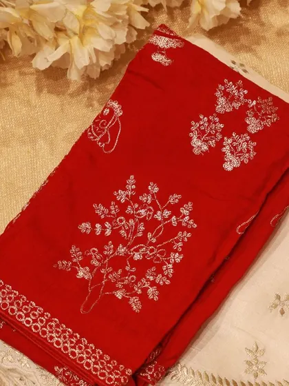 A cream Tussar silk saree with a red hand-embroidered blouse piece, showcasing the beauty of silver zari work.