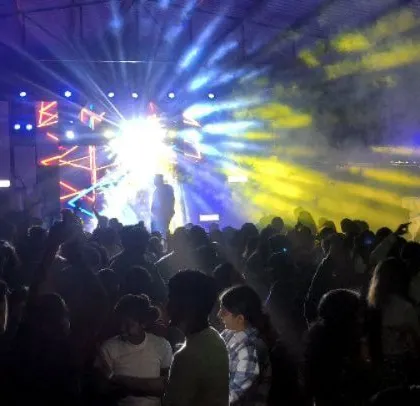 Bright spotlights and smoke create a dramatic effect on the dance floor.