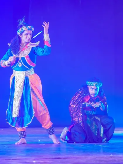 A scene depicting the confrontation between Krishna and Shakuni. The contrast in their body language and costumes visually represents the eternal conflict between dharma and adharma.